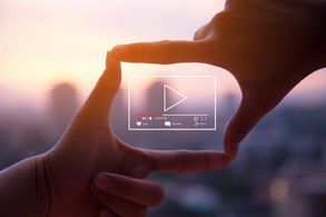 Video gesture made by human hands on blurred sunset sky as background